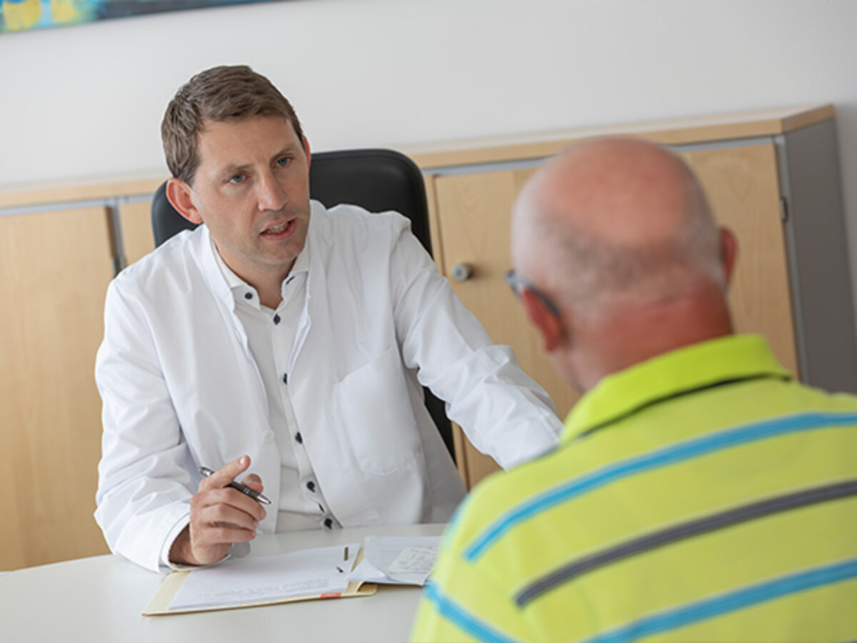 Chefarzt der Fachklinik Donaustauf Prof. Dr. Malfertheiner im Gespräch mit einem Patienten