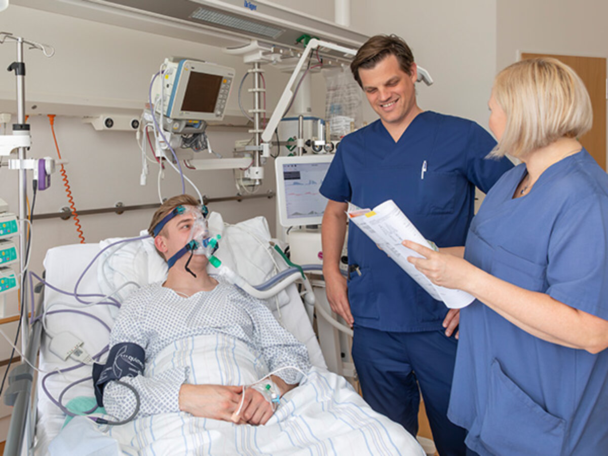 Zwei Mitarbeitende der Klinik für Pneumologie am Caritas-Krankenhaus St. Maria Donaustauf stehen am Bett eines Patienten